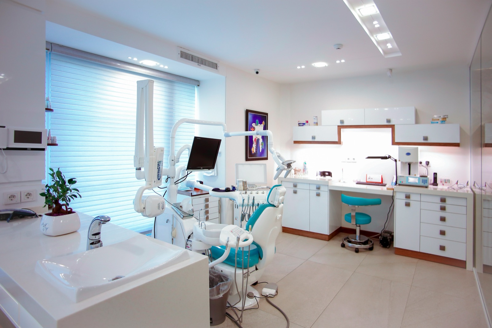A modern dental treatment room with a dental chair and equipment